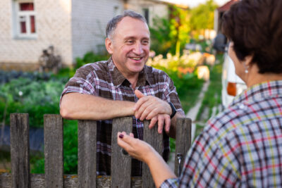 Neighbors,Middle,Aged,Man,And,Woman,Chatting,Near,The,Fence